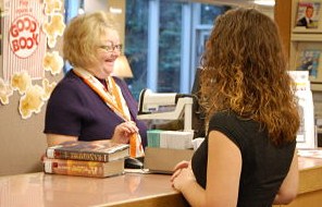 Library employee checking books out to a customer