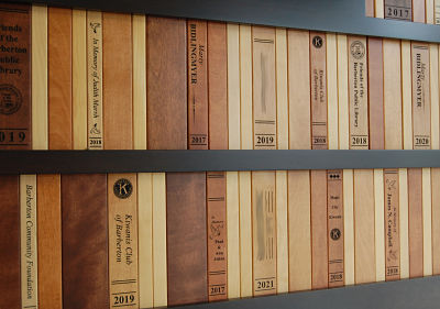 donor, spines of wooden books engraved with donors' names